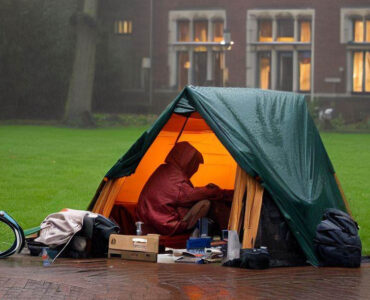 dakloze student kampeert in de regen
