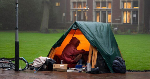 dakloze student kampeert in de regen