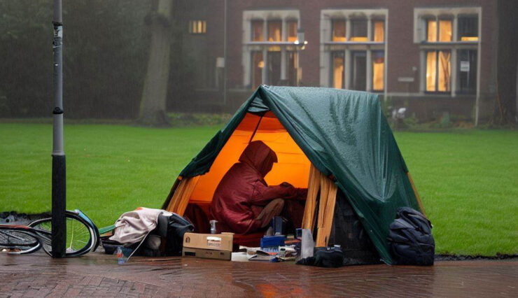dakloze student kampeert in de regen